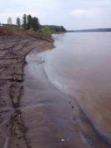 The Athabasca River is slick with an oily sheen.