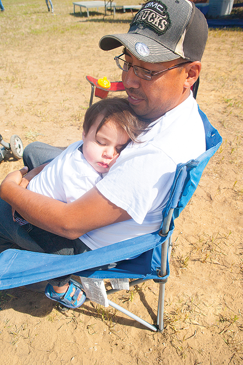 A tuckered out Daniel Jackson Jr. of Fort Good Hope sleeps on his dad, Daniel Jackson.