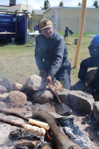 Henry Beaver roasts the outer skin off a beaver tail before it is boiled for lunch.